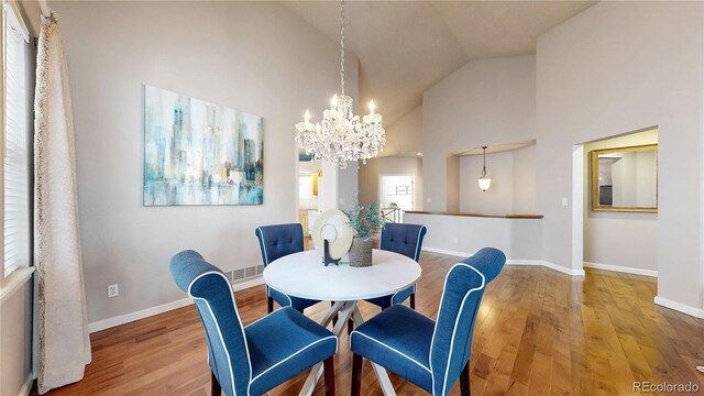 2266 S Kenton St, Aurora, CO 80014 - dining area featuring high vaulted ceiling, an inviting chandelier, wood finished floors, and baseboards