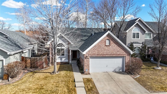 2266 S Kenton St, Aurora, CO 80014 - traditional-style house with driveway, a garage, fence, a front lawn, and brick siding