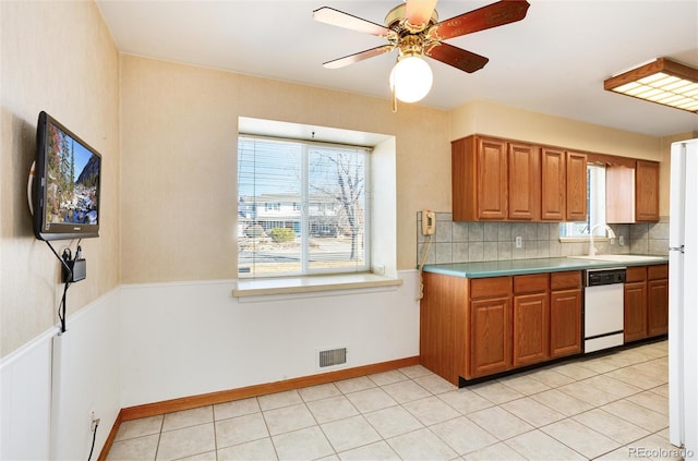 kitchen with sink, white appliances, light tile patterned floors, ceiling fan, and decorative backsplash