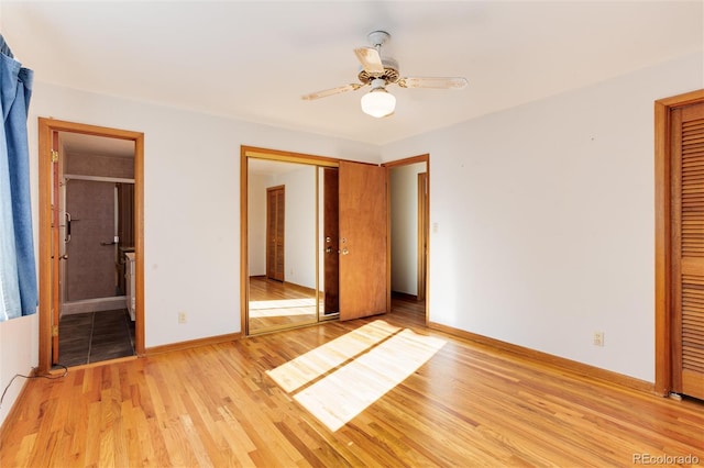 unfurnished bedroom featuring light hardwood / wood-style flooring, a closet, ceiling fan, and ensuite bathroom