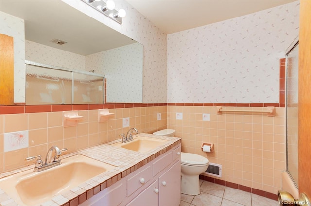 bathroom with vanity, tile walls, tile patterned floors, and toilet