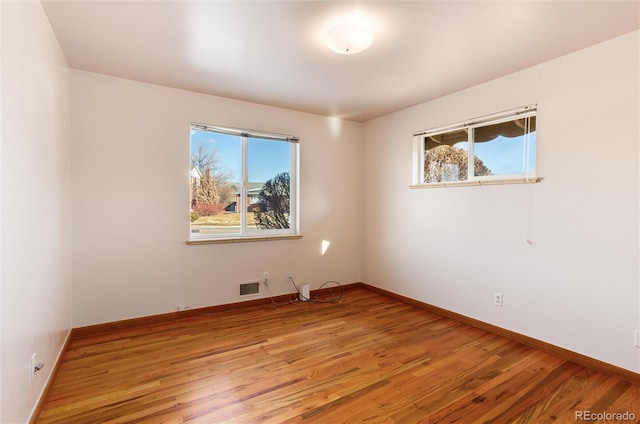 unfurnished room featuring a healthy amount of sunlight and light hardwood / wood-style floors