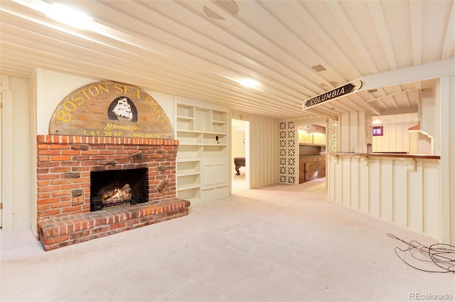 unfurnished living room with built in features, carpet flooring, and a brick fireplace