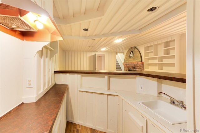 kitchen featuring built in shelves, sink, wooden ceiling, dark hardwood / wood-style floors, and beamed ceiling