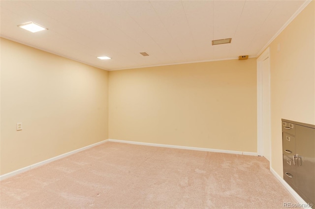 spare room featuring crown molding and light colored carpet