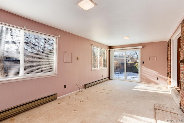 carpeted spare room featuring baseboard heating