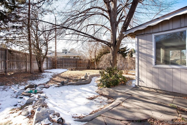 yard covered in snow with a patio area