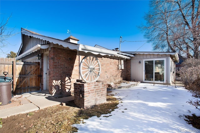 view of snow covered exterior with a patio