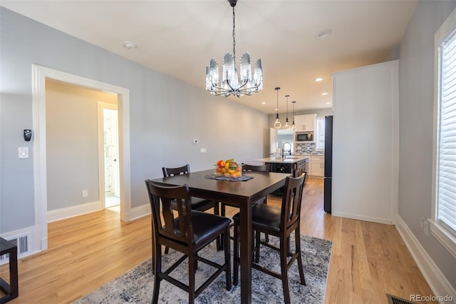 dining space featuring a notable chandelier, recessed lighting, visible vents, light wood-style floors, and baseboards