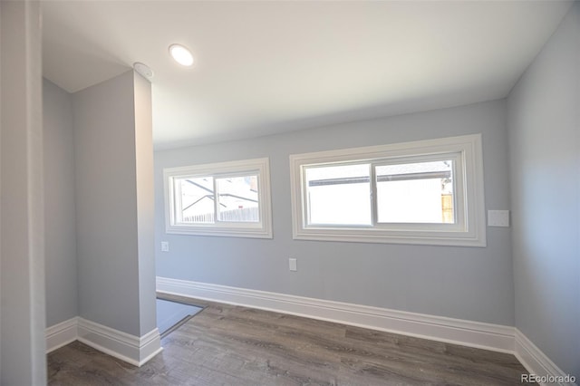 spare room with dark wood-type flooring and baseboards