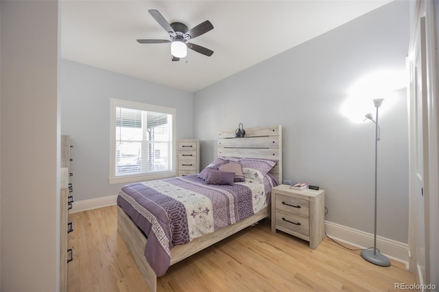 bedroom featuring light wood-type flooring, a ceiling fan, and baseboards