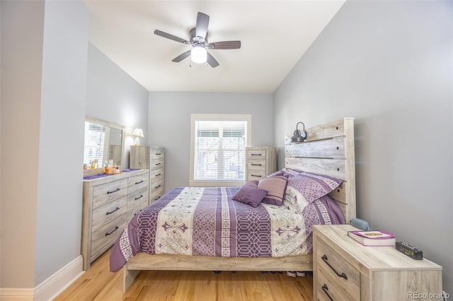 bedroom with a ceiling fan, light wood-style flooring, and baseboards