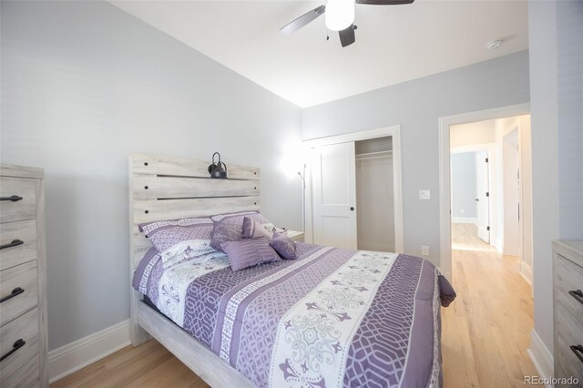 bedroom with ceiling fan, a closet, wood finished floors, and baseboards