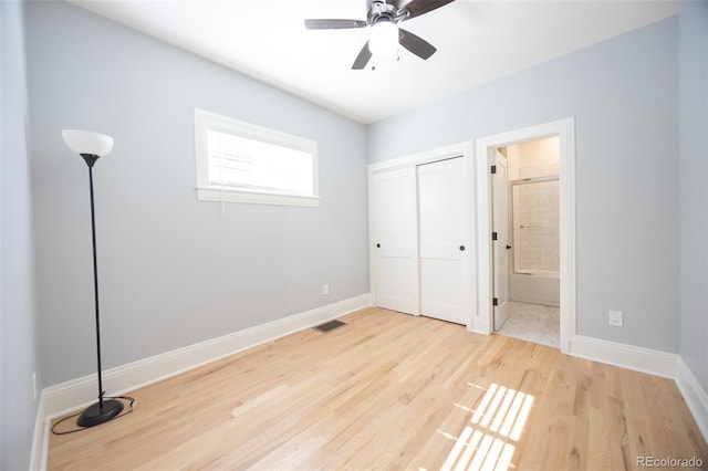 unfurnished bedroom featuring a closet, wood finished floors, visible vents, and baseboards