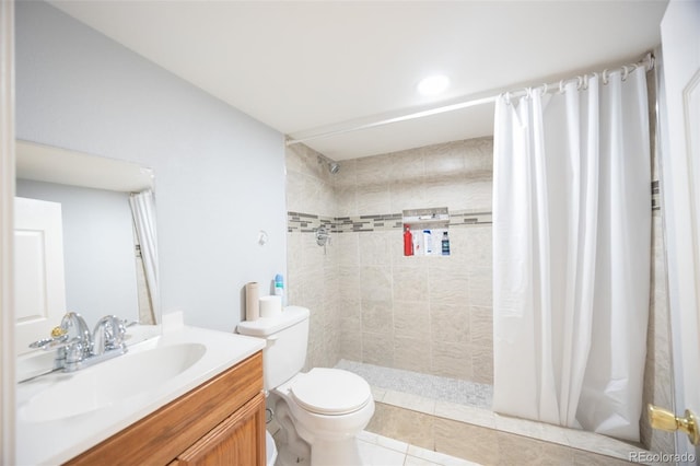 full bath featuring tiled shower, vanity, toilet, and tile patterned floors