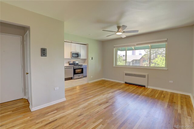 2100 N Franklin St Unit 8, Denver, CO 80205 - unfurnished living room featuring radiator heating unit, a ceiling fan, light wood-style flooring, and baseboards