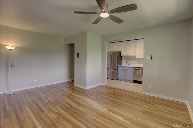 2100 N Franklin St Unit 8, Denver, CO 80205 - unfurnished living room featuring light wood-style flooring, a sink, a ceiling fan, and baseboards