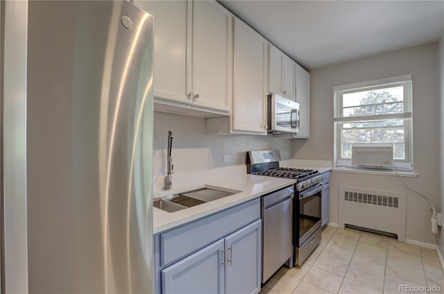 2100 N Franklin St Unit 8, Denver, CO 80205 - kitchen with radiator, stainless steel appliances, a sink, light countertops, and light tile patterned flooring