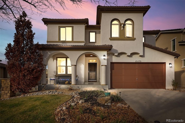 mediterranean / spanish home featuring a porch and a garage