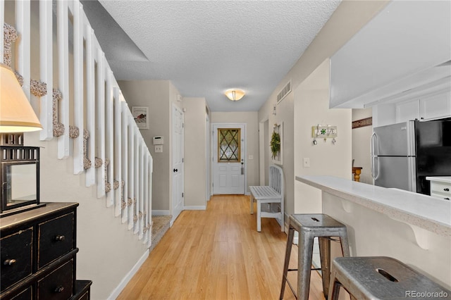 entrance foyer featuring a textured ceiling and light wood-type flooring