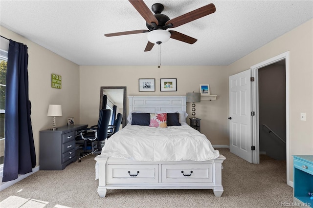 bedroom with light colored carpet, a textured ceiling, and ceiling fan