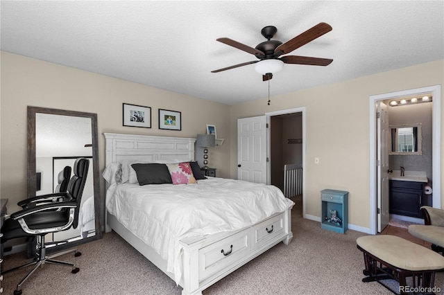 carpeted bedroom with ensuite bath, a textured ceiling, and ceiling fan