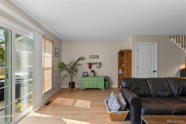 living room with light hardwood / wood-style floors and a textured ceiling