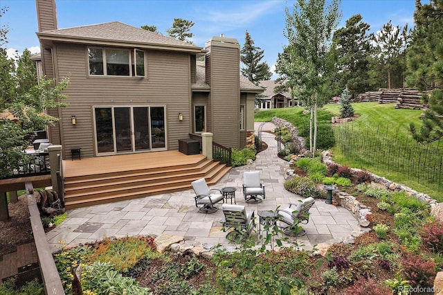 1456 Shavano Ct, Evergreen, CO 80439 - rear view of house featuring a chimney, a patio area, a deck, a lawn, and a shingled roof