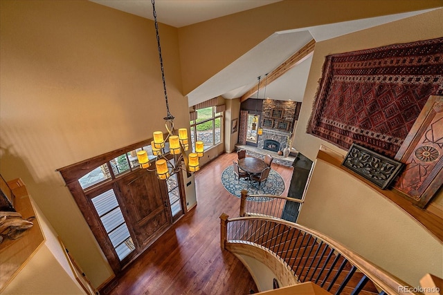 1456 Shavano Ct, Evergreen, CO 80439 - foyer entrance featuring a chandelier, wood finished floors, a stone fireplace, and a high ceiling