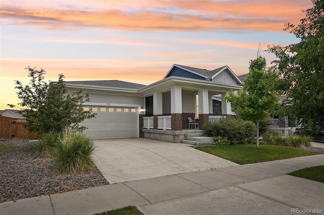 5928 N Odessa St, Aurora, CO 80019 - view of front of home featuring brick siding, concrete driveway, covered porch, an attached garage, and roof with shingles