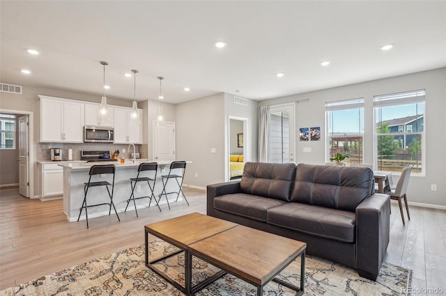 5928 N Odessa St, Aurora, CO 80019 - living area with light wood finished floors, recessed lighting, and baseboards