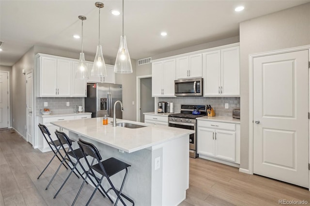 5928 N Odessa St, Aurora, CO 80019 - kitchen with stainless steel appliances, a sink, tasteful backsplash, light wood-style flooring, and light countertops