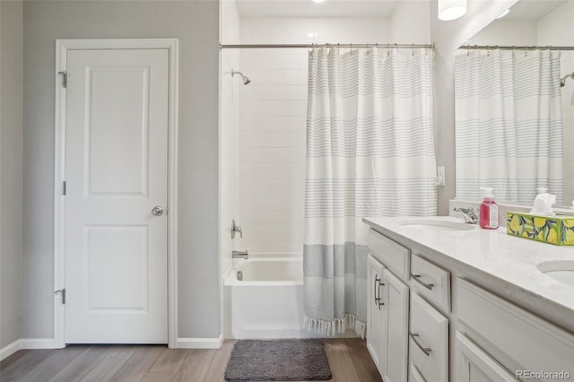 5928 N Odessa St, Aurora, CO 80019 - bathroom with wood finished floors, baseboards, shower / bath combo with shower curtain, and double vanity