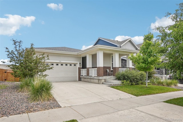 5928 N Odessa St, Aurora, CO 80019 - view of front facade with covered porch, driveway, brick siding, an attached garage, and board and batten siding