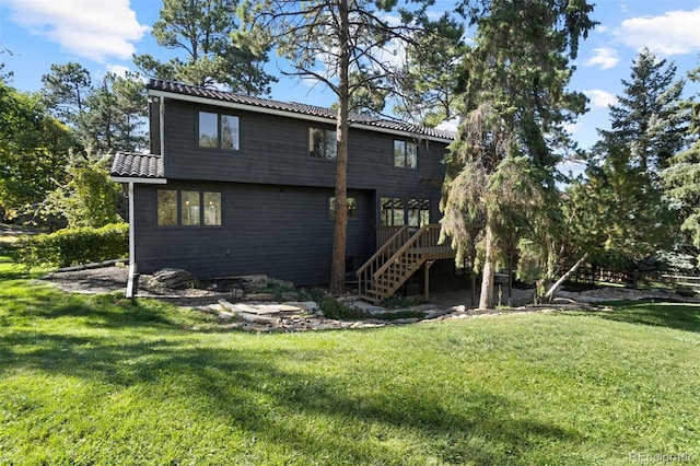 rear view of property featuring a deck and a lawn