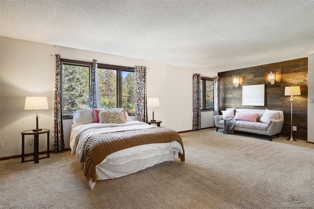 bedroom featuring carpet flooring, a textured ceiling, and wood walls