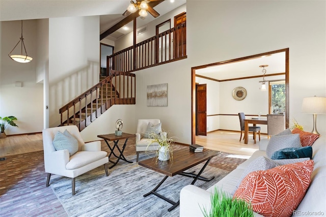 living room with wood-type flooring and a towering ceiling