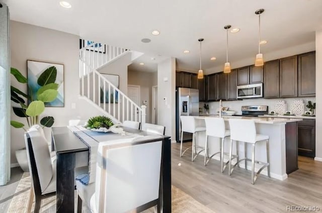 2094 Wagon Wheel Aly, Brighton, CO 80601 - dining room with light wood-style floors, stairway, and recessed lighting
