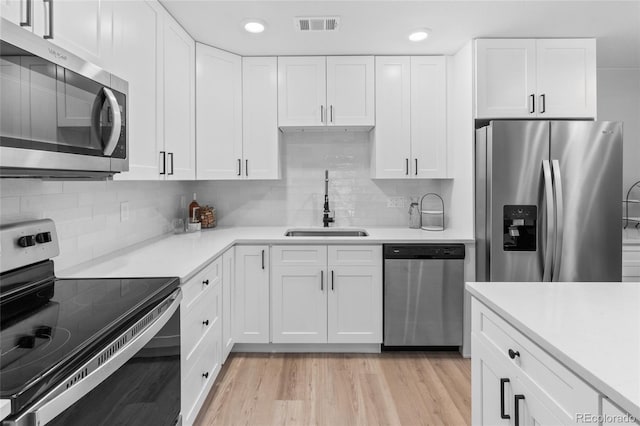 kitchen featuring light hardwood / wood-style floors, sink, white cabinetry, and stainless steel appliances