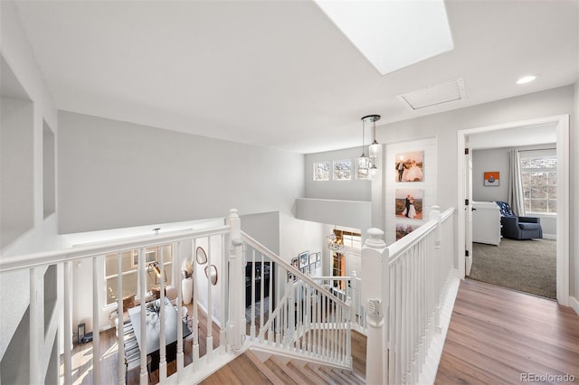 stairs with wood finished floors, recessed lighting, and baseboards