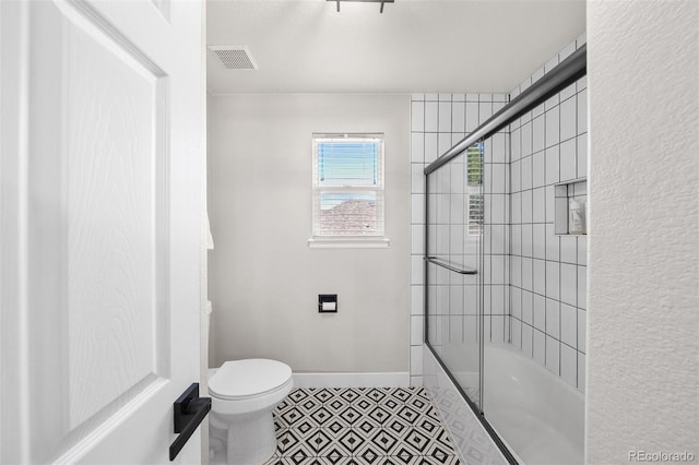 full bathroom featuring toilet, baseboards, and shower / bath combination with glass door