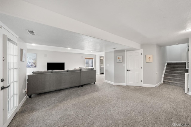 carpeted living area featuring stairs and baseboards