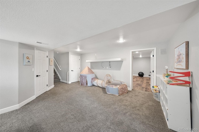 rec room featuring carpet floors, baseboards, and a textured ceiling