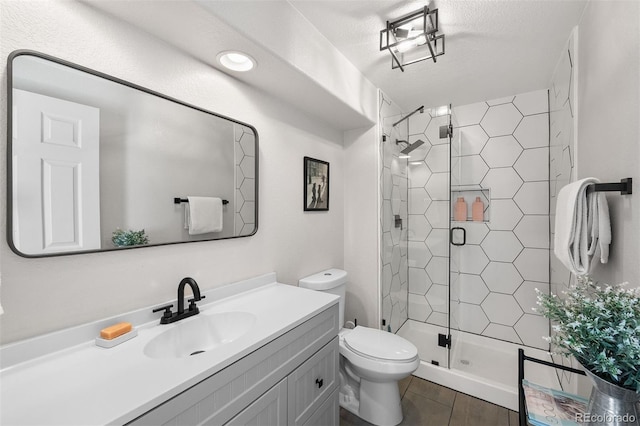 full bathroom featuring toilet, a shower stall, and vanity