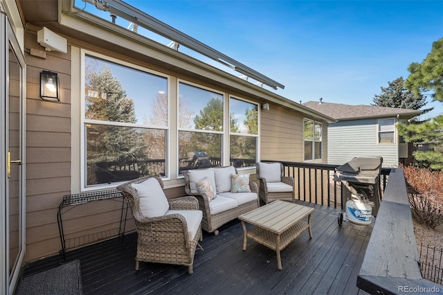 wooden terrace with an outdoor living space and area for grilling