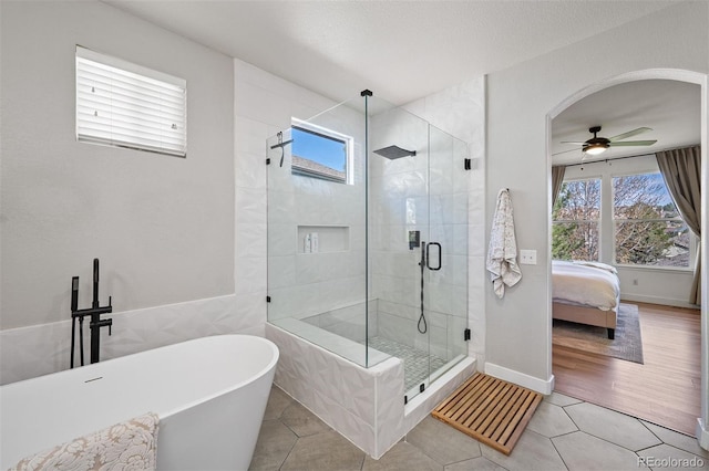 1053 Snow Lily Ct, Castle Pines, CO 80108 - ensuite bathroom featuring a freestanding bath, healthy amount of natural light, a stall shower, and ceiling fan