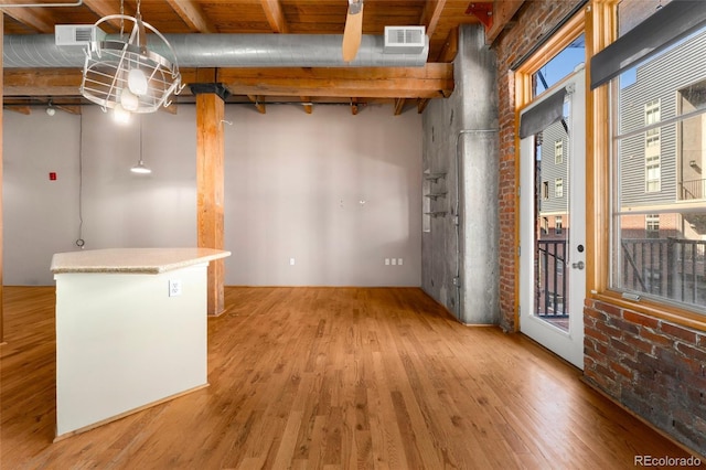 foyer entrance with light wood-style floors and beam ceiling