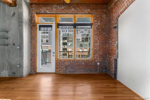 entryway featuring wood finished floors and brick wall