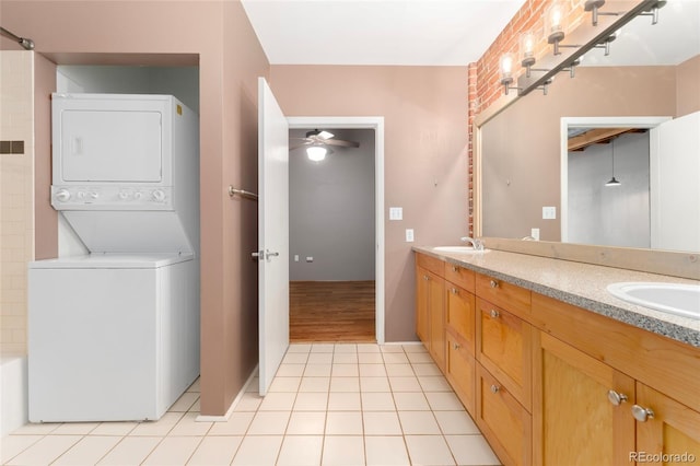 full bathroom featuring stacked washer / dryer, a ceiling fan, double vanity, tile patterned flooring, and bathtub / shower combination
