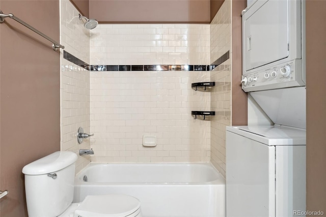 bathroom featuring stacked washer / dryer, toilet, and bathing tub / shower combination